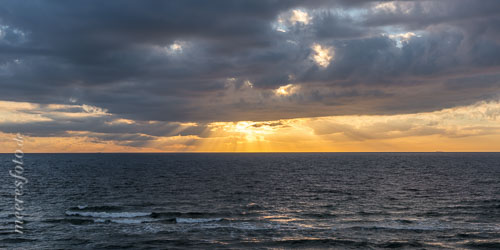  Sonnenstrahlen brechen durch die Wolken am Horizont der Ostsee vor Ahrenshoop