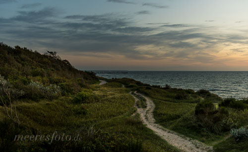  Ein Weg durch die Landschaft oberhalb der Steilküste zwischen Ahrenshoop und Wustrow im warmen Licht nach einem Sonnenuntergang
