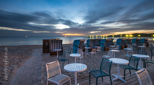  Stühle, Tische und Strandkörbe im Licht der aufgehenden Sonne am Strand von Binz