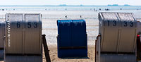  Ein blauer Strandkorb mit Blick über das Watt der Nordsee auf Föhr an einem heißen Sommertag