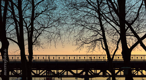 Die U-Bahnbrücke zwischen Landungsbrücken und Baumwall im Gegenlicht des Sonnenuntergangs