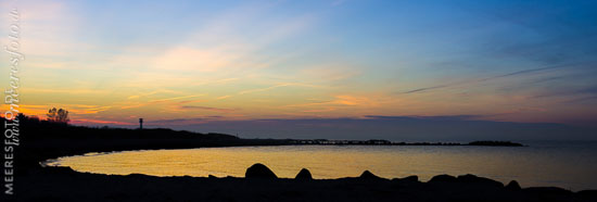 Steinbuhnen im markanten Gegenlicht der untergegangenen Sonne am Ostseeufer von Heidkate.