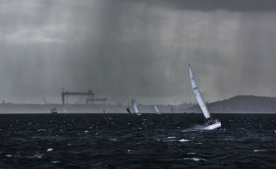 Segler im Regenschauer auf der Kieler Förde bei starken Windböen –  DETAIL: Segelboote fahren Richtung Kieler Hafen durch einen Schauer mit Starkregen.