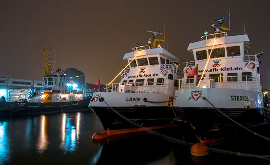 Die Fährschiffe „Laboe“ und „Strande“ von der Schlepp- und Fährgesellschaft Kiel unter nächtlichem Himmel in der Kieler Hörn