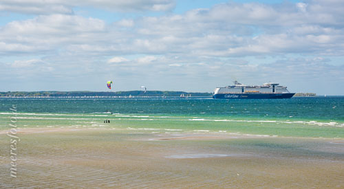  Die Sandbänke vor Laboe im strahlenden Sonnenlicht mit Colorline-Fähre, Segelregatta und Kitesurfern.