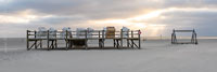  Duschanlage und Holzpfahlpodest mit Strandkörben im Licht des Sonnenuntergangs am Strand von Sankt Peter-Ording