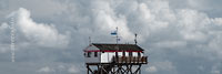  ARBEITSTITEL: Das Pfahlhaus der Badeaufsicht am Strand von Sankt Peter-Ording vor einer dramatischen Wolkenkulisse