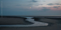  Der Mond steht über einem Priel am Nordseeufer vor  Sankt Peter-Ording