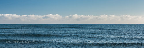 Sanfte Ostseewellen und eine Wolkenbank am sommerlichen Horizont vor dem Sehlendorfer Strand