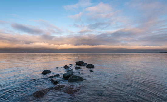 Eine Steinbuhne in der Ostsee der Neustädter Bucht vor dem Timmendorfer Strand im letzten Licht der untergehenden Sonne