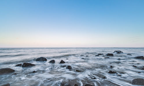 Zurückfließende Ostseewellen – Wasser zieht auf diesem Foto durch Steine im Uferbereich vor Brodten ab.