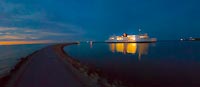  Ausfahrt in die Nacht vor Puttgarden –  DETAIL: Eine Ostsee-Fähre verlässt am späten Abend den Hafen von Puttgarden in Richtung Rødby. Das Bild ist als farb- und kontraststarke Foto-Grafik erstellt.