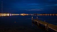  Ferienzentrum von Heiligenhafen bei Nacht –  DETAIL: Das Foto zeigt einen nächtlichen Blick über den Binnensee von Heiligenhafen, auf das Ferienzentrum und die farbige Beleuchtung um den See. Die Beleuchtung wechselt mit fließenden Übergängen ihre Farbigkeit und erzeugt Nachts eine sehr schöne Stimmung.