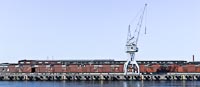  Lagerhallen mit Krahn im Lübecker Hafen –  DETAIL: Harter Kontrast und markante Farbigkeit, lassen dieses Foto aus dem Lübecker Hafen in einer sehr sachlichen – fast unwirklichen – Stimmung wirken.