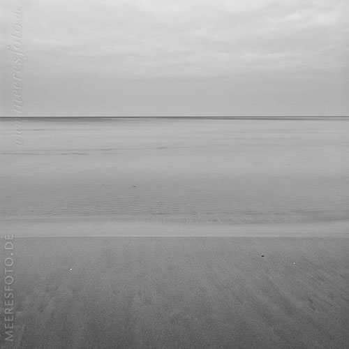  Stille am Strand von Kalifornien an der Ostsee – schwarzweiß –  DETAIL: Dieses ruhige Schwarzweiß-Foto zeigt ein Detail des Strandes von Kalifornien mit Blick auf die Ostsee und die Kieler Bucht.