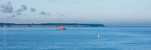 Der Leuchtturm Kiel in der Kieler Aussenförde und ein klassischen Segelboot aus Holz an einem Sommermorgen