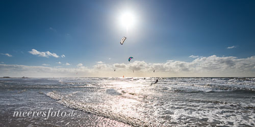 Kitesurfer im Gegenlicht der Sonne am Strand von Sankt Peter-Ording