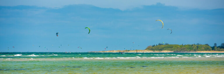 Kitesurfer vor Stein im Sonnenlicht