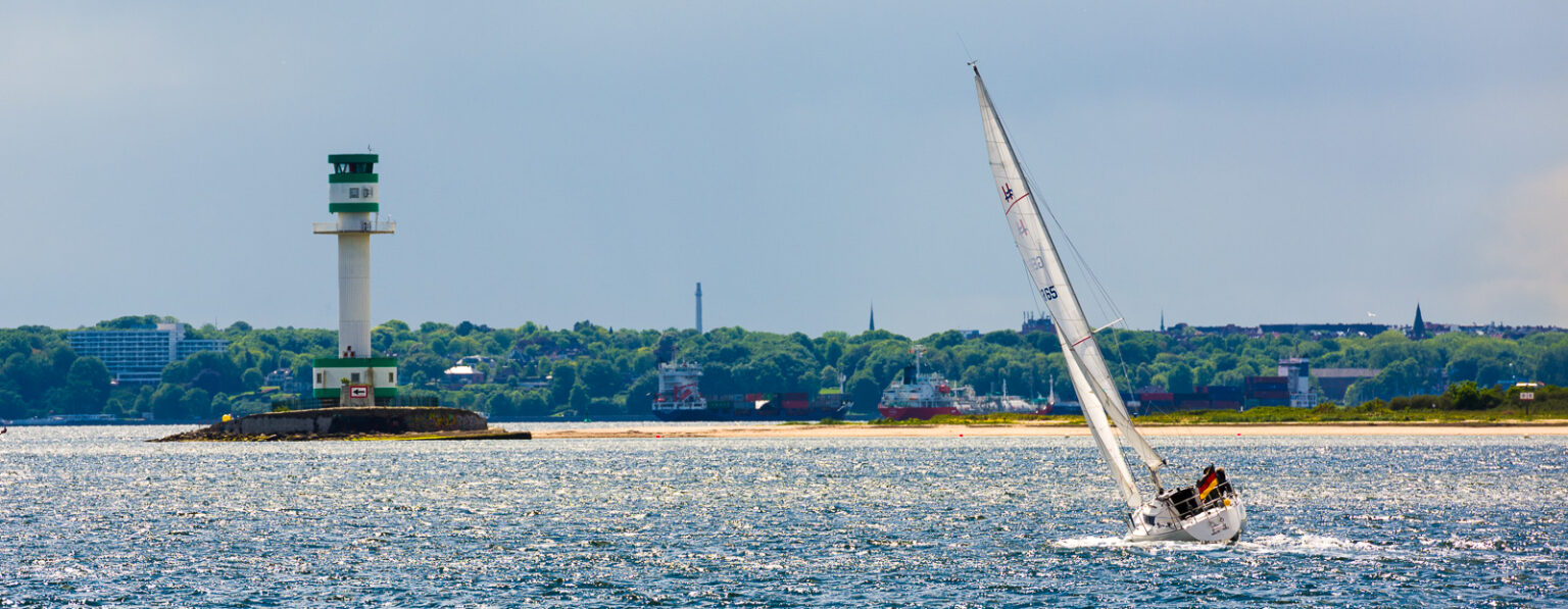 Leuchtturm Friedrichsort und Segler im Sonnenlicht